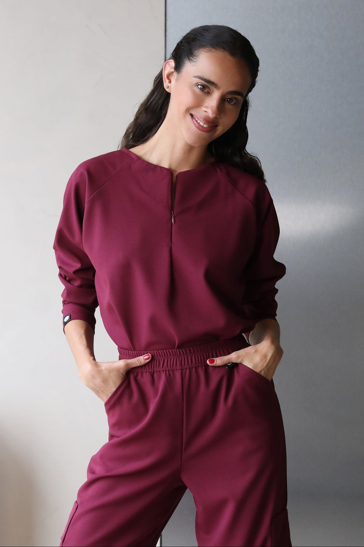 Model wearing Fall Burgundy Scrub Top with matching scrub pants