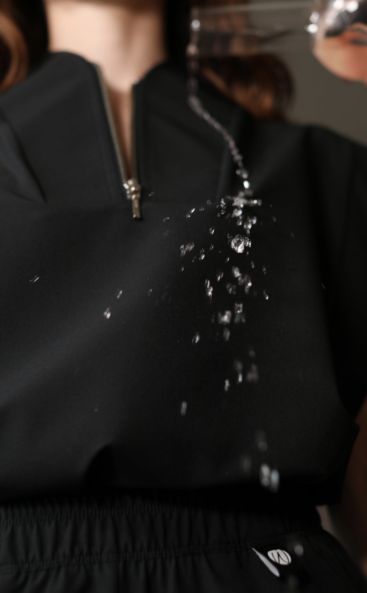 Detalle de líquido transparente formando gotas sobre la tela negra de la Filipina Kate W&C Shield™.